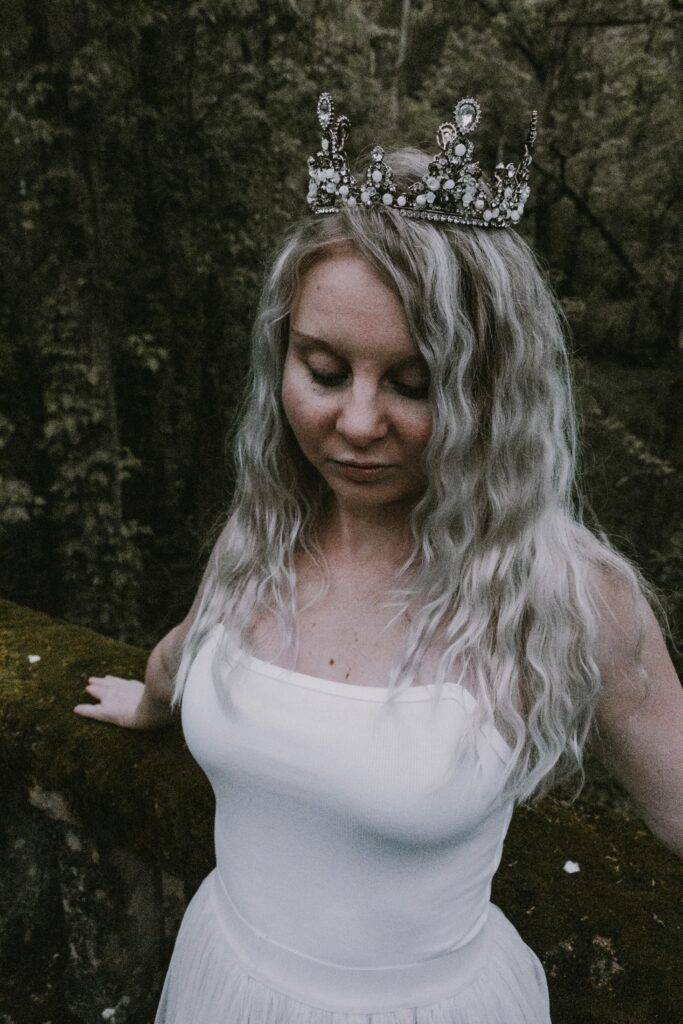 Photography of Stephanie in a crown, looking down, thinking about her DNA story.